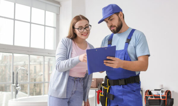 Portrait of woman and plumber in bathroom